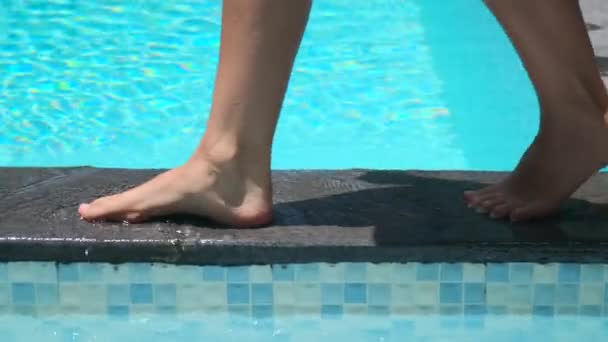 Kvinnliga fötter går på poolgränsen — Stockvideo