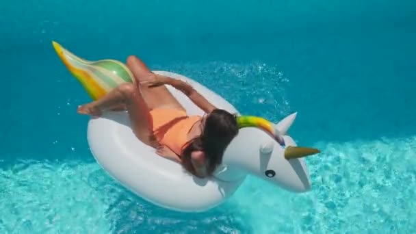 Donna è abbronzatura su anello di gomma unicorno in piscina — Video Stock