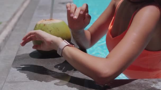 Handen van jonge vrouw communiceren door een smartwatch in een zwembad — Stockvideo