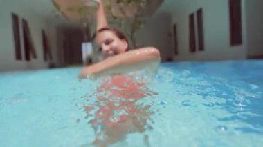 Genç bayan havuzda eğleniyor.