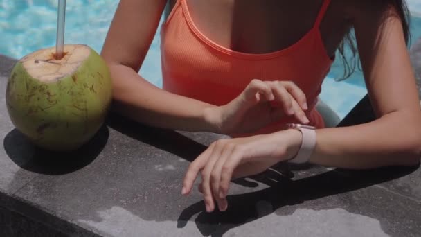 Manos de una joven activa tocando la pantalla de un reloj inteligente en la piscina — Vídeos de Stock