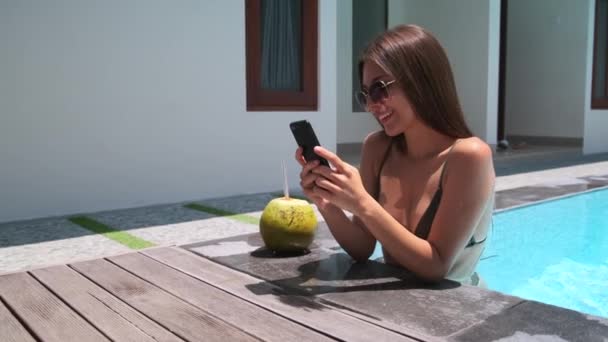 Donna sta riposando in piscina, utilizzando smartphone — Video Stock