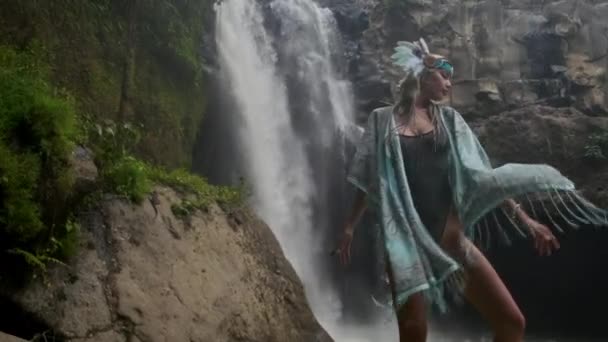 Donna etnica sta posando vicino alla cascata nella foresta — Video Stock