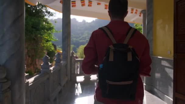 Neznámý muž kráčející po terase buddhistického chrámu — Stock video