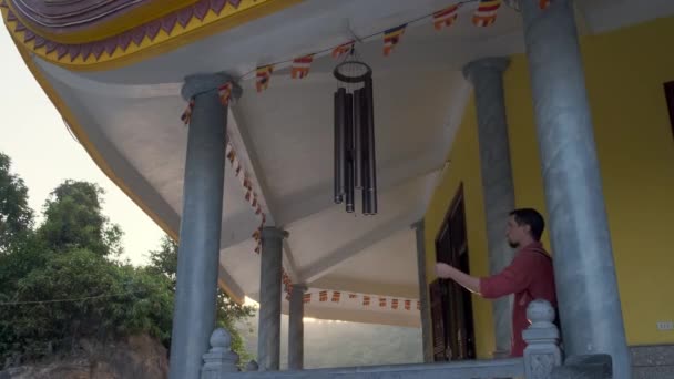 Tourist spielt in buddhistischem Tempel Musik mit Windglocken — Stockvideo