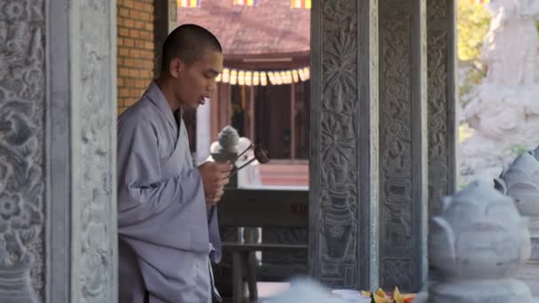 Зосереджений буддійський монах молиться з закритими очима в буддійському храмі. — стокове відео