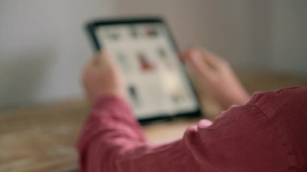 Mies katselee tuoteluettelo Internet-sivustolla myymälä, käyttämällä tabletti — kuvapankkivideo