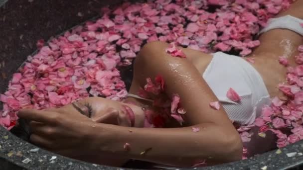 Spa, piękne kobiety korzystających z kąpieli z płatków kwiatów — Wideo stockowe