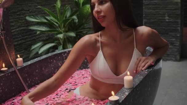 Mujer está disfrutando de baño con flores en el spa — Vídeo de stock
