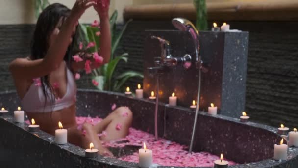 温泉，年轻的女士在浴池里与花花瓣共浴 — 图库视频影像