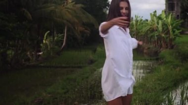 Muhteşem bir kadın yeşil pirinç tarlasında dönüp duruyor.