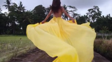 Özgürlük düşkünü kadın pirinç tarlalarında koşuyor.