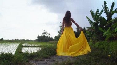 Uzun elbiseli zarif bir kadının yalnız yürüyüşü