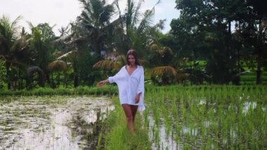 Turist kadın Bali 'de pirinç tarlalarında yürüyor.