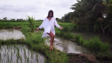 Yeşil pirinç tarlasında yürüyüş yapan muhteşem bir kadın.