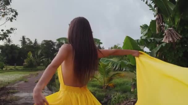 熱帯性の黄色のドレスを着た女性は — ストック動画