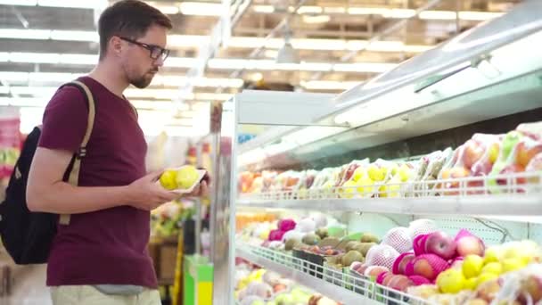 Comprador masculino está comprando frutas en el supermercado — Vídeos de Stock