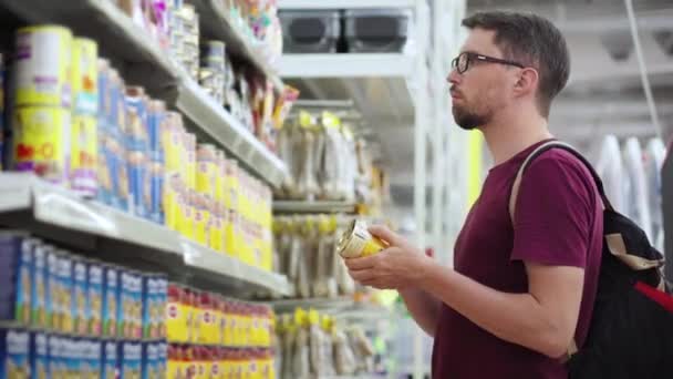 Comprador está eligiendo alimentos enlatados para gatos en el supermercado — Vídeos de Stock