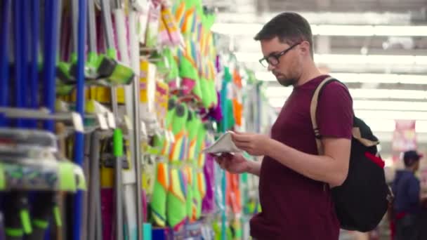 Shopping in ipermercato, l'uomo sta scegliendo le merci per la casa — Video Stock