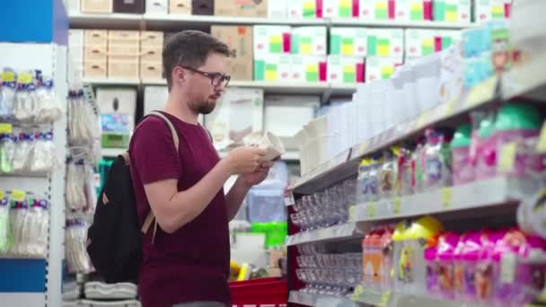 Joven macho está comprando tazas de porcelana en un centro comercial — Vídeos de Stock