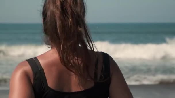A nő az óceánhoz rohan. Intenzív futás után frissítő vizet akar. — Stock videók