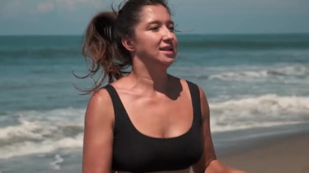 Woman is training alone on sea beach in summer vacation — Stock Video