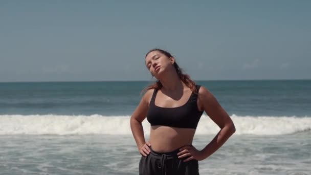 Ginástica matinal na praia do oceano, mulher está realizando exercícios — Vídeo de Stock