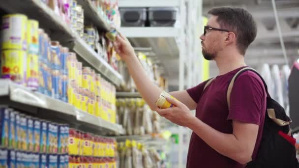 Cliente en el supermercado eligiendo alimentos enlatados para mascotas — Vídeos de Stock