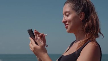 Hareketli kadın koşudan önce müziği cep telefonundan seçiyor.