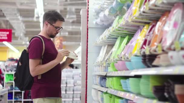 Cliente uomo che sceglie stoviglie nell'ipermercato — Video Stock