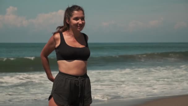 Gymnastics on oceanic beach, woman is training — Stock Video