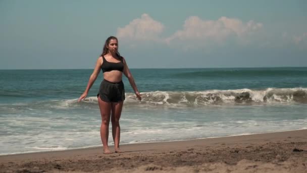 Body positive movement supporter woman is doing exercises at ocean beach — Stock Video
