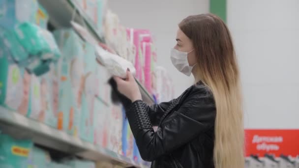 Signora in maschera medica acquisto di pannolini per bambini nel supermercato — Video Stock