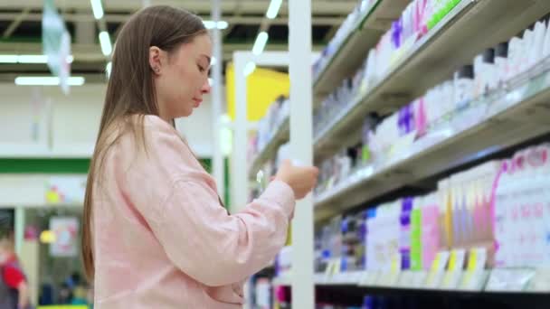 Молодая женщина покупает антиперспирант в супермаркете — стоковое видео