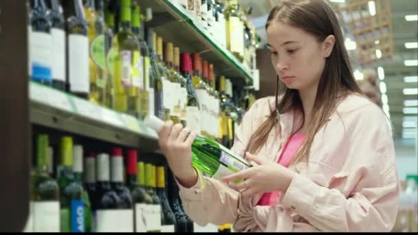 Vrouw kiest champagne in wijnwinkel — Stockvideo
