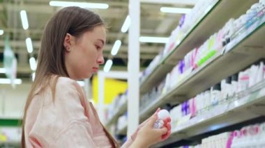 Kadın alıcı kozmetik dükkanında roll-on deodorantı seçiyor.