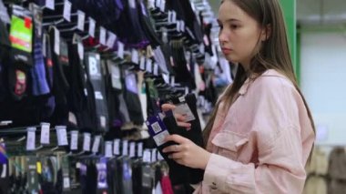 Genç kadın süpermarketten çorap alıyor.
