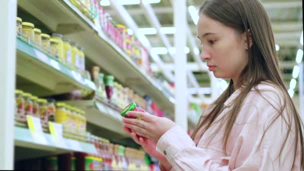 Meisje koopt glazen pot eten in de supermarkt — Stockvideo