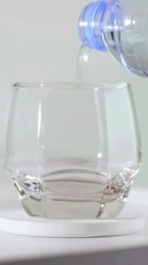 Bir bardak suyu kapat, yumuşak odaklan. Tahta masadaki şişeden temiz temiz içme suyunu bardağa döküyorum. Rahatlatıcı bir sabah. Sağlıklı Konsept