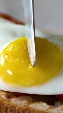Baharatlı yumurtalı sandviçe yakın, kızarmış ekmeğin üzerinde yumurta sarısı. 