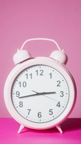 ピンクアラーム時計 12時 タイムトラブルが速い 矢を動かして時計 クロックフェイスはランニングタイムを示します タイムコンセプト — ストック動画