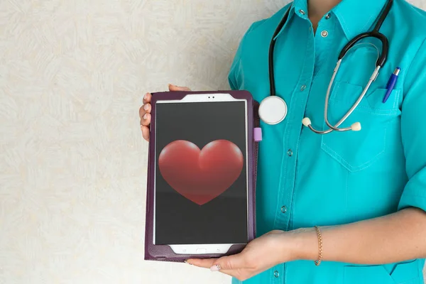 Doktor kalp resmi ile bir tablet tutuyor
