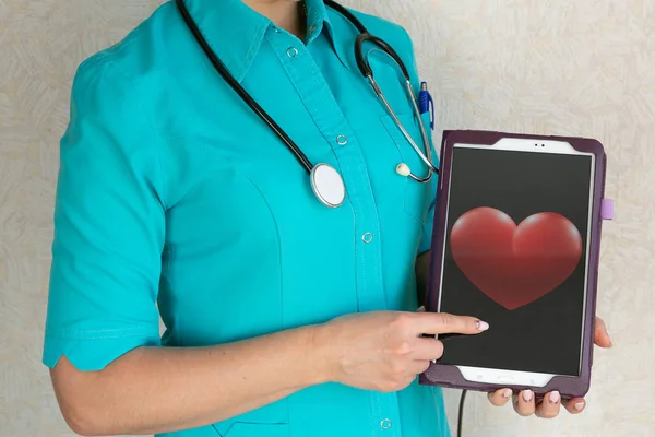 Doktor kalp resmi ile bir tablet tutuyor