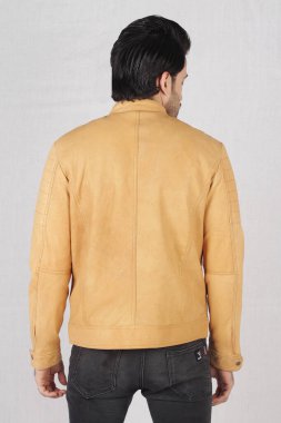 Kahverengi ceketli ve kot pantolonlu adam.