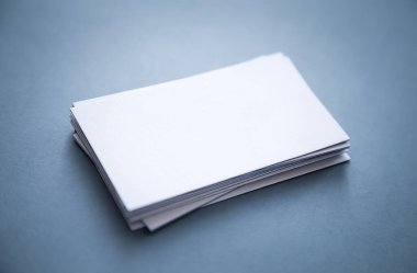 Gri arka planda birikmiş, ön ve arka köşeleri bulanık, kalın, boş kartvizitler..