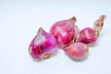 Reklam alanı için beyazda izole edilmiş taze kırmızı soğan yığınının yakın görüntüsü.