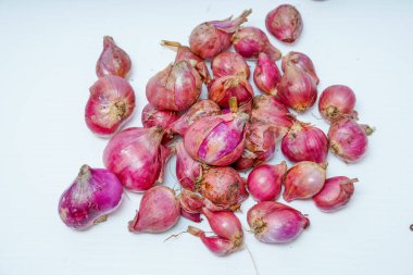 Reklam alanı için beyazda izole edilmiş taze kırmızı soğan yığınının yakın görüntüsü.