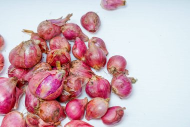 Reklam alanı için beyazda izole edilmiş taze kırmızı soğan yığınının yakın görüntüsü.