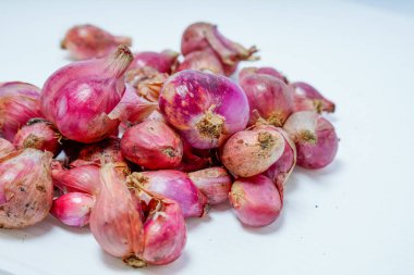 Reklam alanı için beyazda izole edilmiş taze kırmızı soğan yığınının yakın görüntüsü.