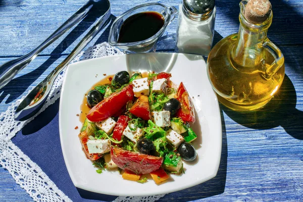 Görög saláta friss uborka, paradicsom, édes paprika, fejes saláta, feta, olajbogyó, olívaolaj, balzsamecet és tengeri só. Felülnézet. Egészséges Sammer élelmiszer. Ragyogó napfény fénykép mediterrán stílusban. — Stock Fotó